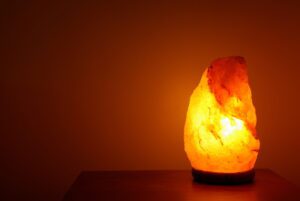 Crystal salt lamp lit in a room to make the atmosphere zen.