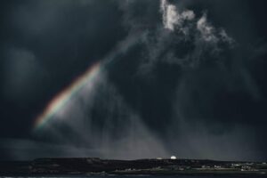 a storm with a rainbow through the clouds