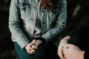 two people sitting together with folded hands