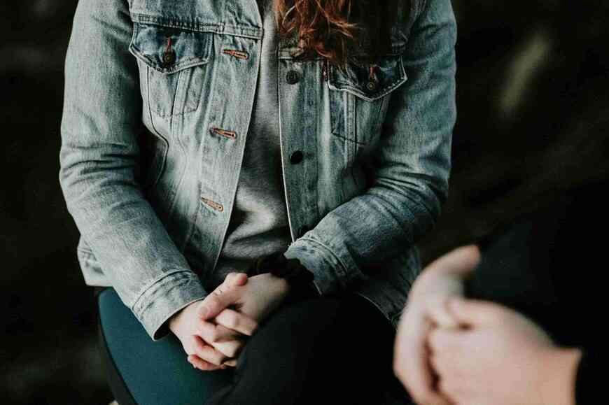 two people sitting together with folded hands
