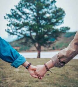 2 people holding hands Photo by Dương Hữu on Unsplash